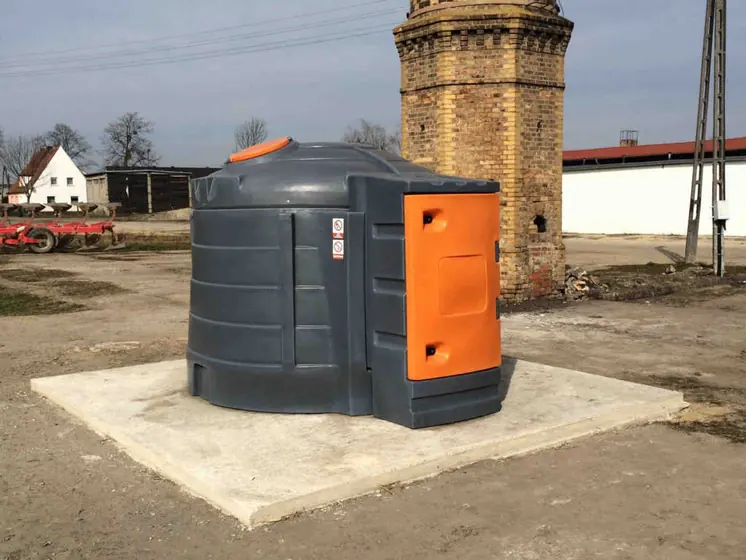 Dwupłaszczowy zbiornik na olej napędowy z pomarańczową szafką na betonowej płycie